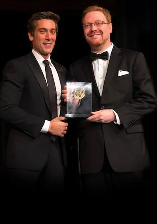 Matthew Schwartz accepting the Edward R. Murrow Award from David Muir